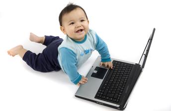 Image of a baby using a laptop smiling