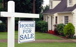 House for sale sign hanging in front of a house