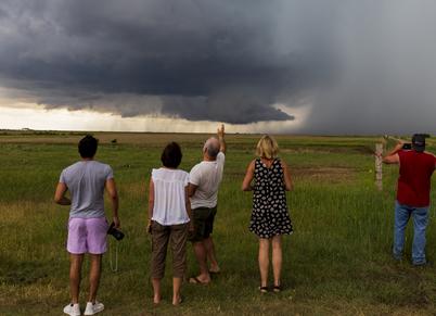 Storm chasing tour guests filming a large wall cloud