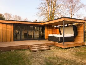 Modern cedar clad garden room with 5 panel bifold doors, hot tub enclosure and integral shed built by Robertson Garden Rooms