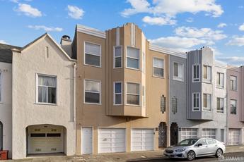 Photo of the exterior of 1616-1618 Judah St., SF. Tan, art deco-style duplex in the Outer Sunset District of San Francisco.