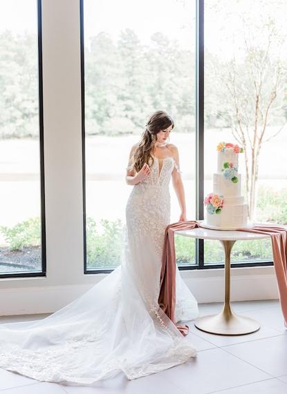 Beautiful bride with wedding cake on a specialty table with velvet runner