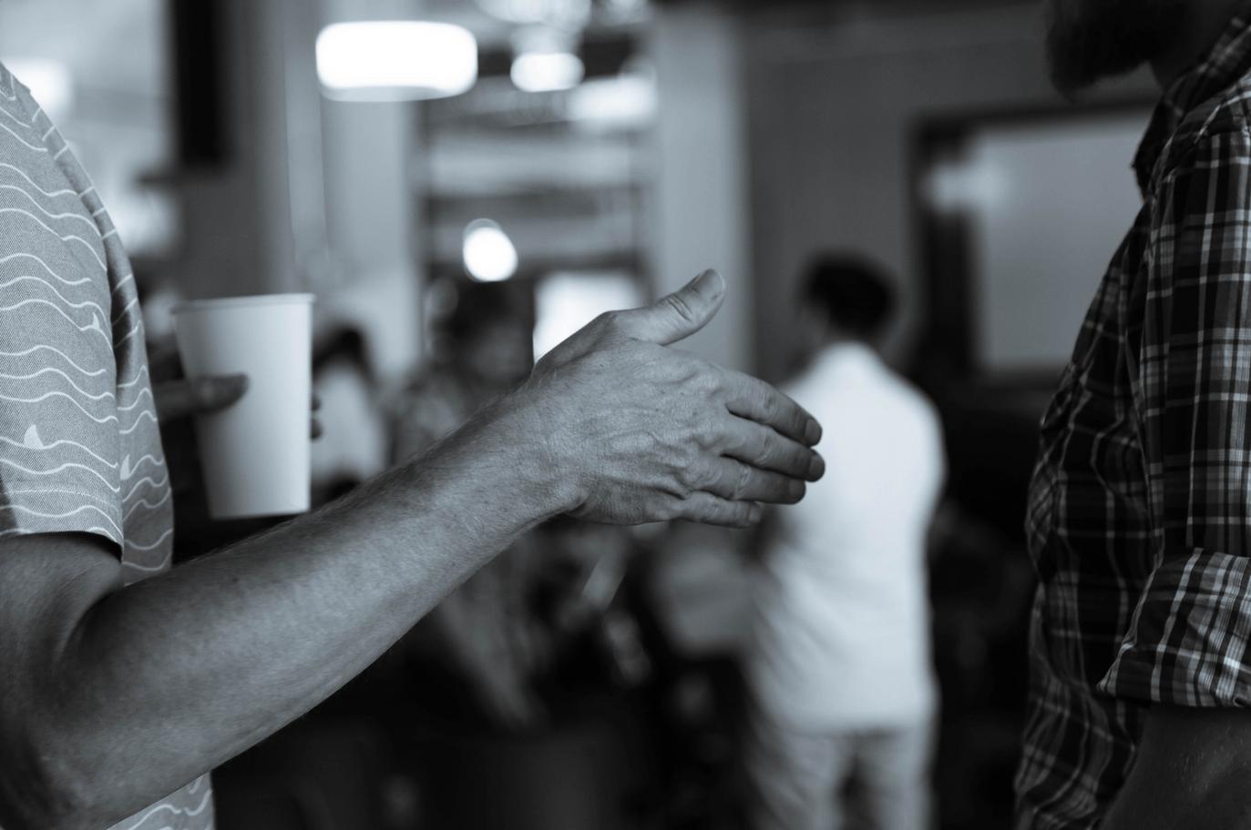 male reaching out hand for deal black and white