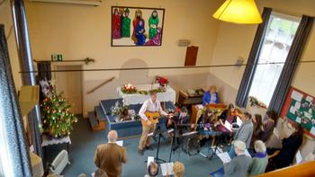 Image of people worshiping inside church building