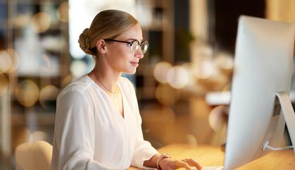 Business woman working at the office looking at a computer.