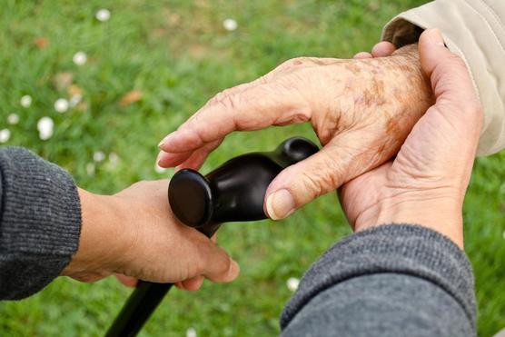 Elderly senior hands grasping a cane