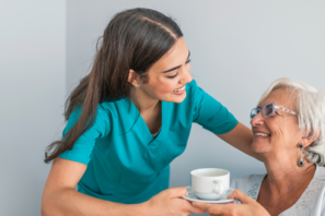 Nurse serving a cup of tea to assisted living senior