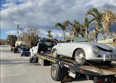 Two of our tow trucks picking up old flooded cars.