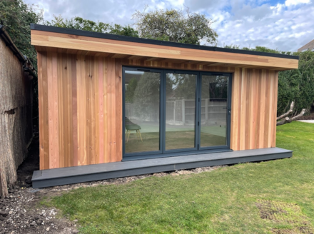Modern cedar clad garden room with 3 panel bifold doors