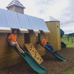 Picture of Big and Little Hank coming down the slides on Hank's Wooden Barn and Silo Play structure