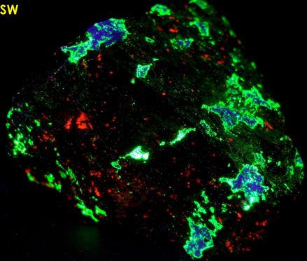 fluorescing Willemite, Hardystonite, Calcite, Clinohedrite, black Franklinite, yellow Andradite garnet,Franklin Mine, Franklin, Franklin Mining District, Sussex County, New Jersey