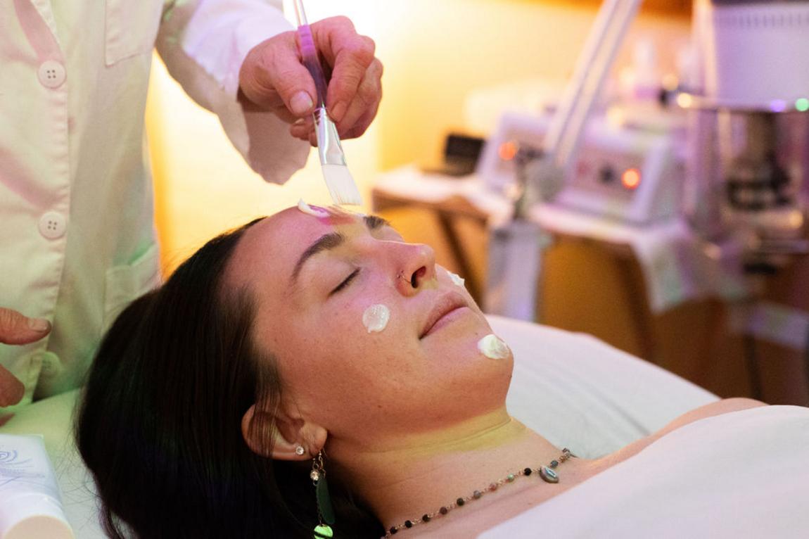 Client receiving a facial after a massage by a massage therapist