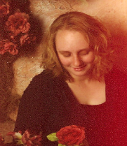 Jourdan, looking down at a flower held in her hand.