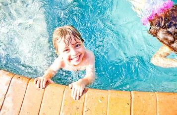Kid in pool smiling photo
