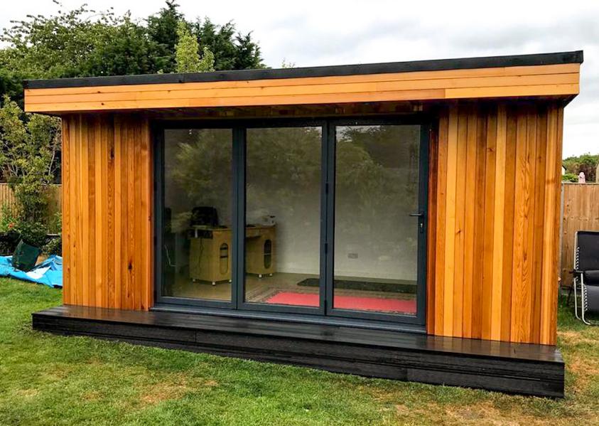 Modern cedar clad garden room with 3 panel bifold doors in Nazeing, Essex built by Robertson Garden Rooms