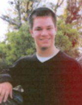 Trevor's senior picture, outdoors, standing and smiling at camera