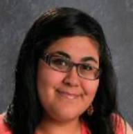 Maribel senior picture, smiling, looking at the camera wearing her glasses.