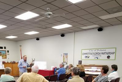 A man talks to an audience in the City Hall.