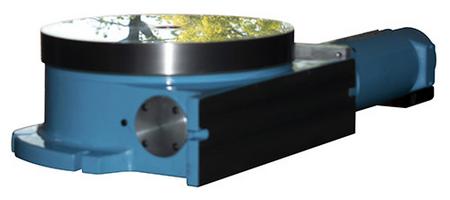 A rotary grinding table shown with trees and sky reflecting off its table top
