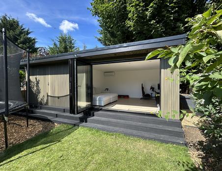 Garden room with beige slatted cladding and open 3 panel bifold doors