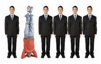 People in Suits with Odd One Standing on His Head
