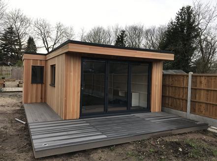 Modern cedar clad garden building with 3 panel bifold doors and 2 windows