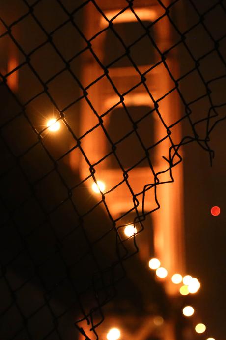 golden gate bridge through fence at night
