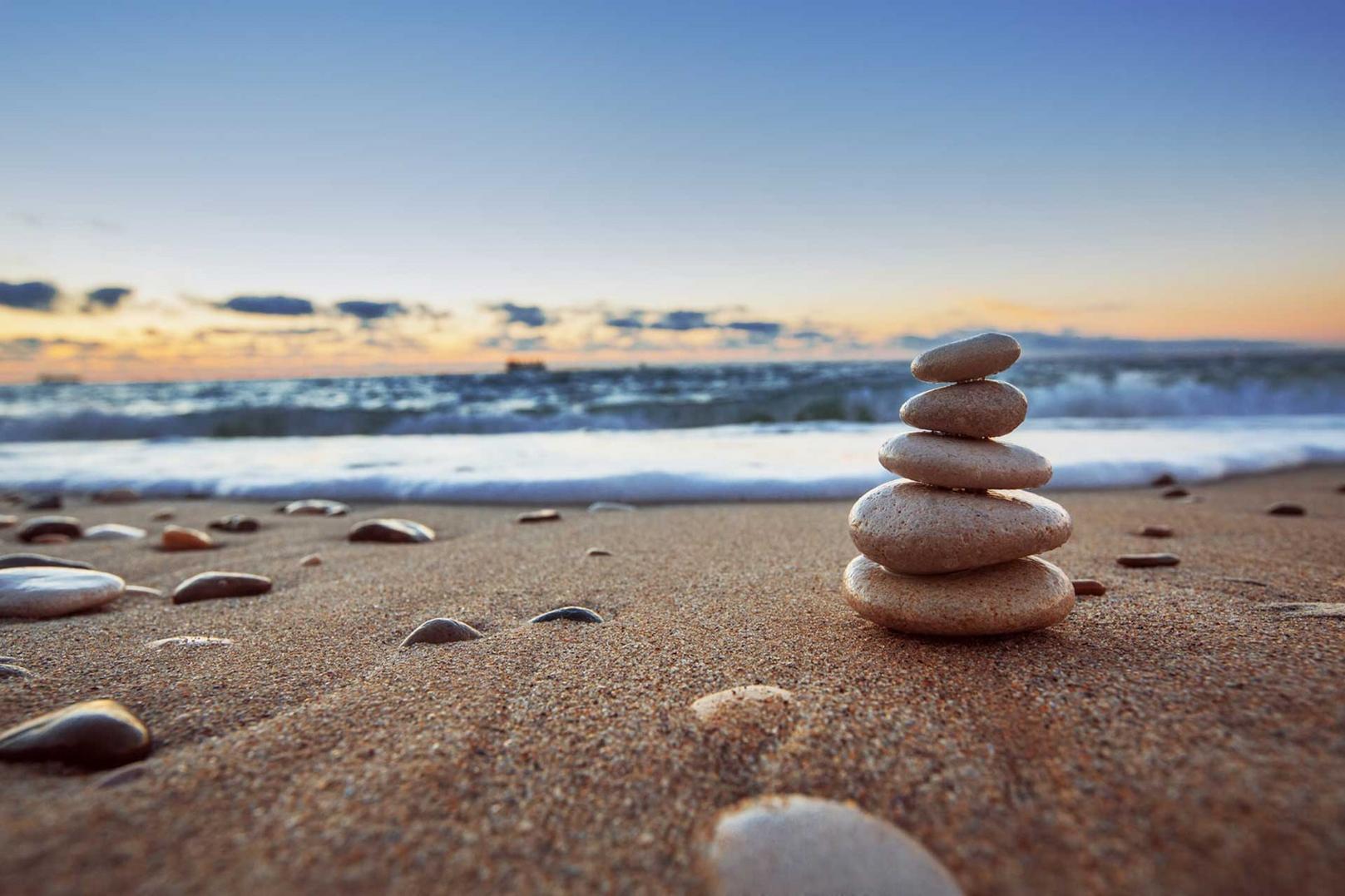 Close up of beach at sunset with rocks stacked