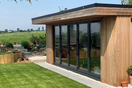 Modern cedar clad garden room with 5 panel bifold doors