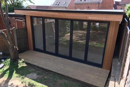 Modern cedar clad garden room with 5 panel bifold doors
