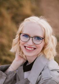 An outdoor picture of Emma, smiling, looking at the camera