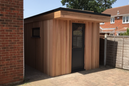 Modern cedar clad garden office with central black door