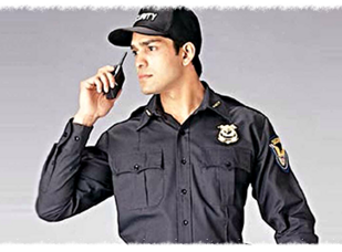 A uniformed security officer talking on his radio