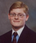 Chris's senior picture, wearing suit and tie, smiling, looking at camera