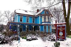 1870 Wedgwood Inn is adjacent to 1833 Umpleby House. Winter scene: front view of the painted Wedgwood blue Victorian inn with snow in front yard.