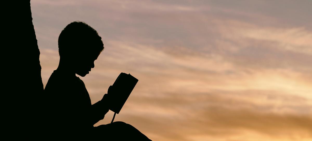 child reading under a tree