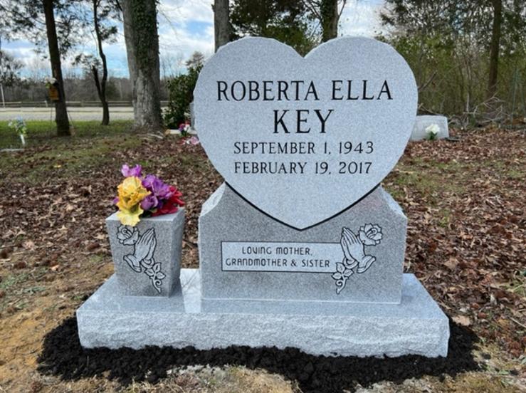 heart shaped tombstone with a flower vase