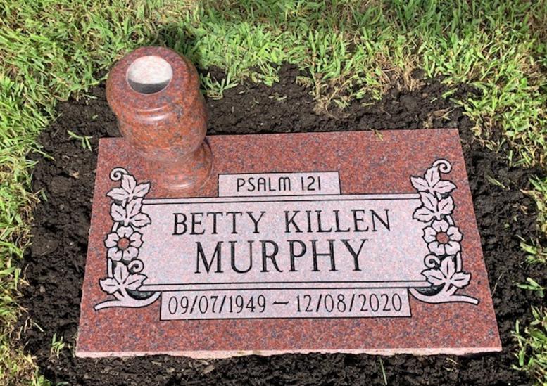 flat grave stone in ruby red granite with a flower vase