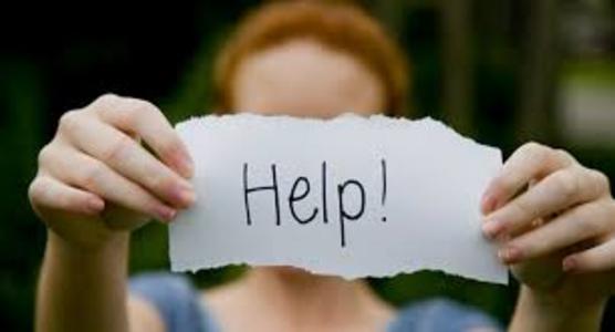 A woman holding a paper asking for help with her hoarding home situation in Pasco County (New Port Richey, FL).