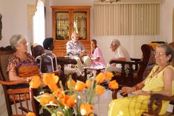 Elderly residents of Featherstone Assisted Living Community siting in rocking chairs mingling