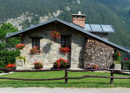 House with mountain background flowers in front windows