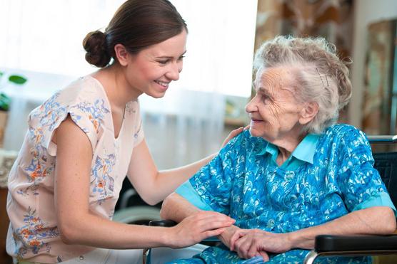 Women comforting elderly women in wheelchair
