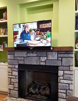 flat screen tv mounted over fireplace with down and out mount pulled down from over the fireplace, charlotte nc flat panel television installation company