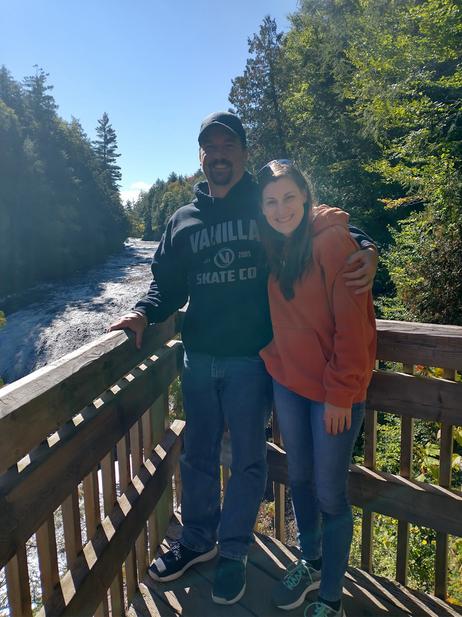 Adoption Profile Photo. Jessica and Nathan standing on a lookout point. Rushing river and waterfall behind them.