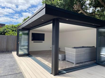 Black slatted garden building with corner bifold doors and bar