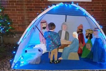 Image of child looking at tent with nativity scene inside