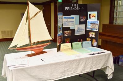 Photo of a FriendShip informational table set up at an event with flyers and organizational information.
