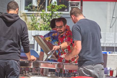 male barbecue interaction outdoors on sunny day