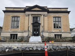 Front shot of library building with retaining wall and boulder wall.