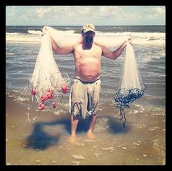 man holding a seine net over his shoulders